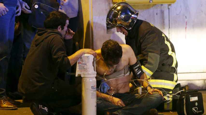Los bomberos atienden a uno de los heridos. / Reuters