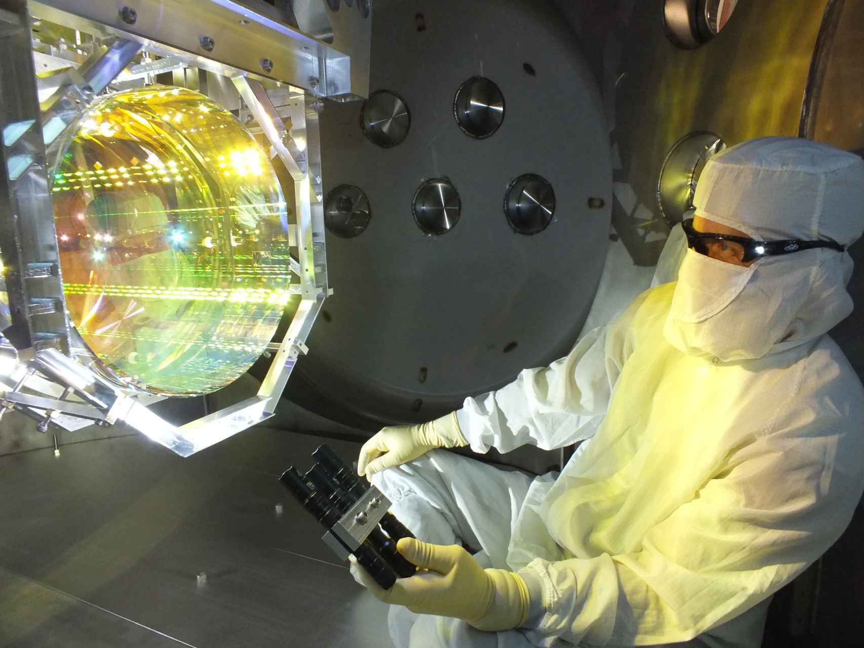 Un técnico revisa uno de los espejos del LIGO para eliminar impurezas.