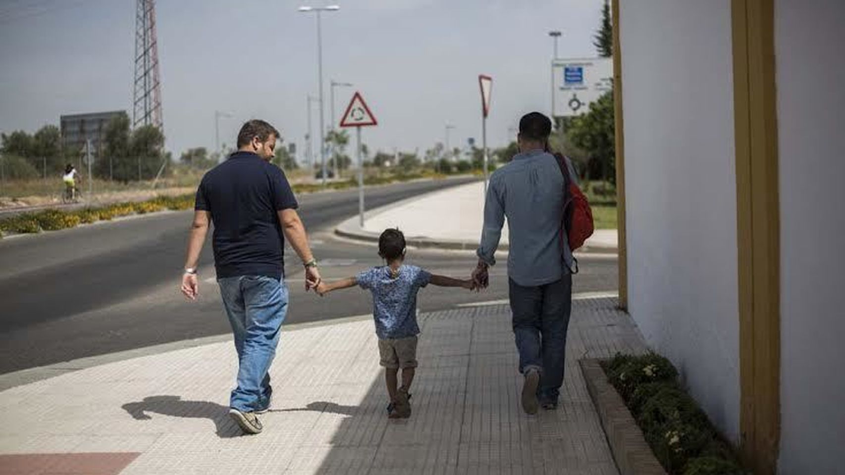 Julián y Agustín, una pareja gay, caminando junto a su hijo.