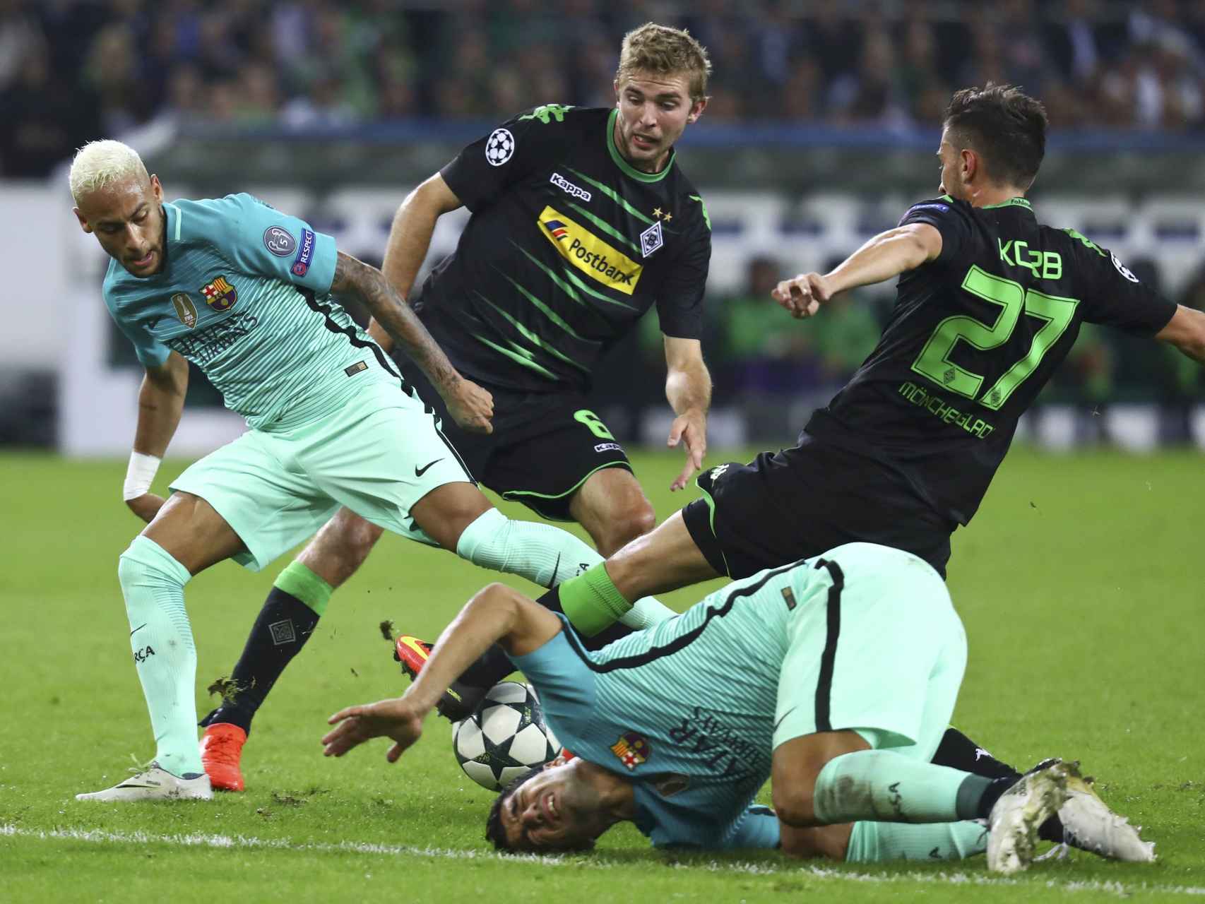 Neymar pelea por el balón mientras Súarez se duele en el suelo. / Reuters