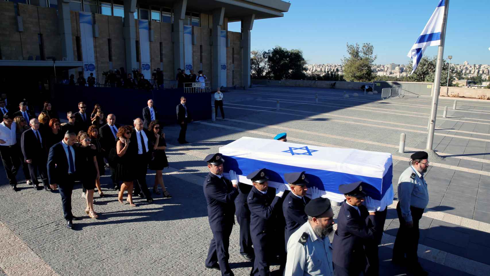 Familiares de Simón Peres flanquean su féretro durante una ceremonia en la Knesset, el Parlamento israelí, antes de su traslado al cementerio del  Monte Herzl, donde se han reunido los líderes locales y mundiales para rendir homenaje al último fundador de Israel. Imagen: Ammar Awad/ Reuters