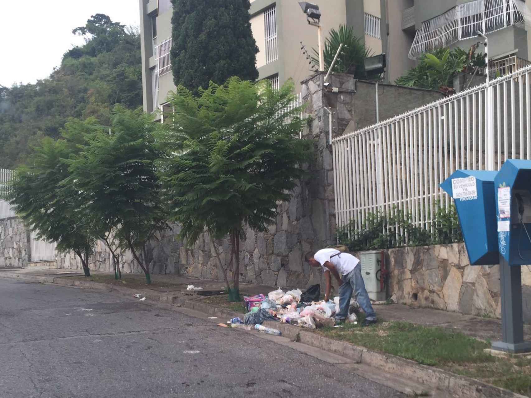 Un hombre buscando comida en la base en Caracas.