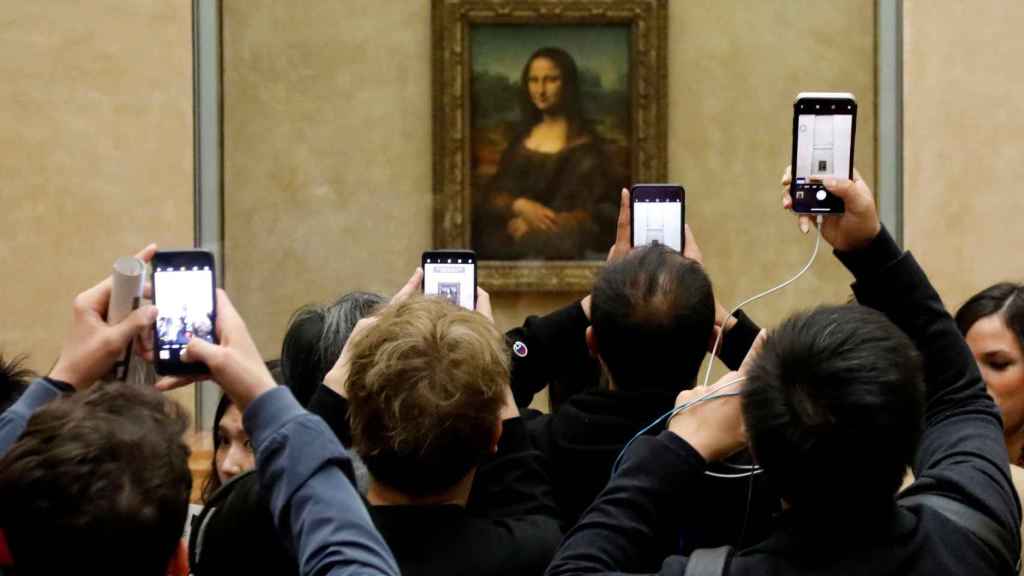 Visitantes del Louvre fotografÃ­an a 'La Gioconda' con sus telÃ©fonos mÃ³viles.
